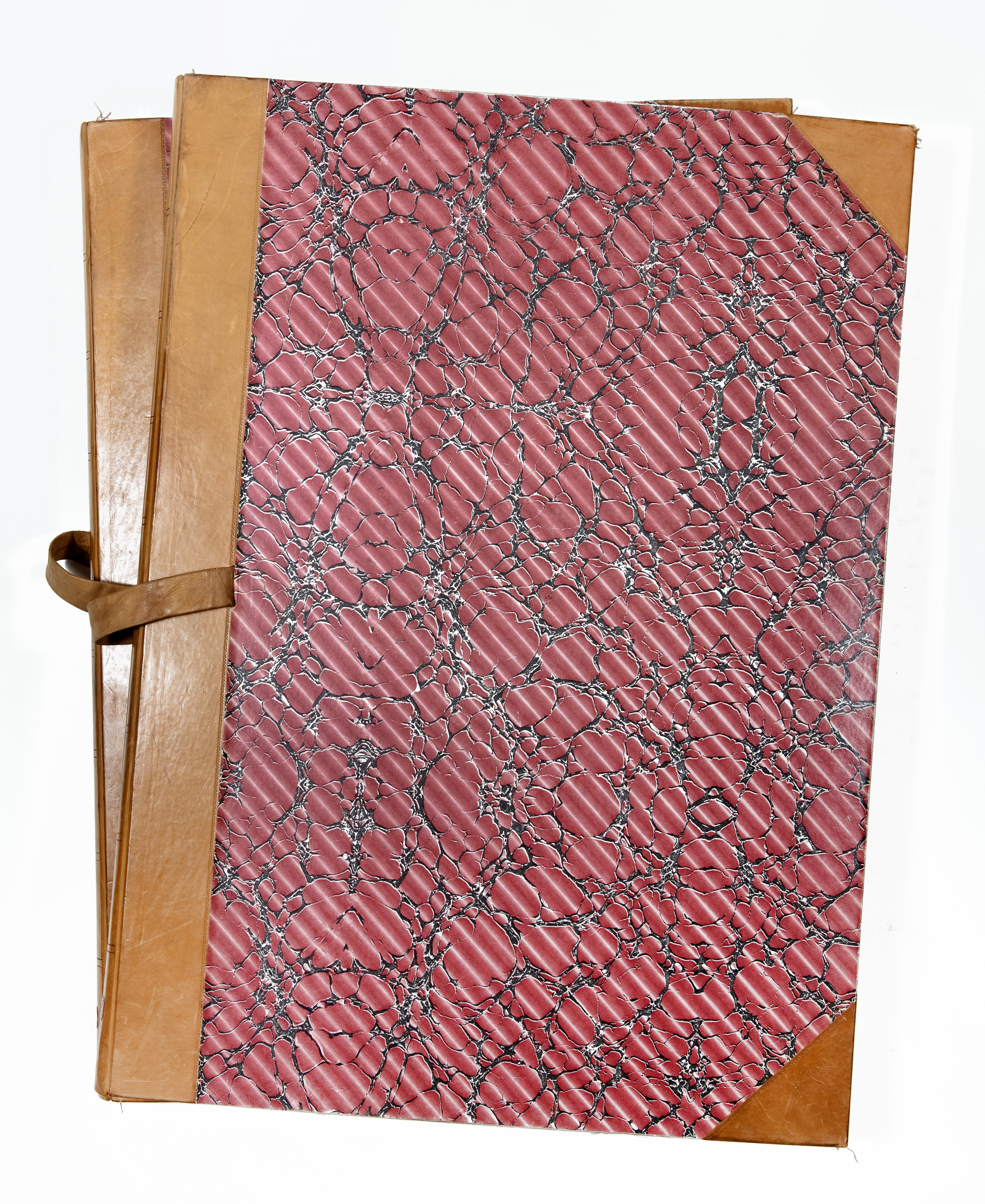 Zwei übereinander gestapelte Alben, die mit rot gemustertem Steinmarmorpapieren und an den Ecken und am Rücken mit braunem Leder bezogen sind