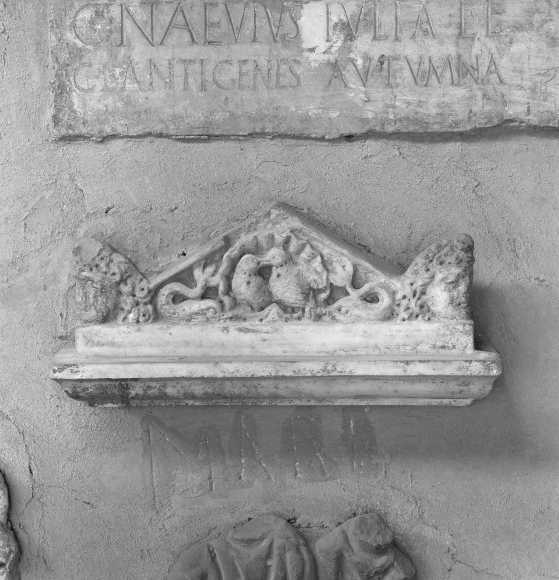 Schwarz-Weiß-Fotografie eines antiken Giebelreliefs im Kreuzgang der Kirche San Paolo fuori le mura in Rom 
