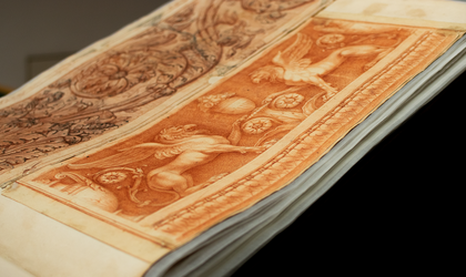 Blick in einen aufgeschlagenen Klebeband, in dem zwei eingeklebte Rötelzeichnungen zu sehen sind.